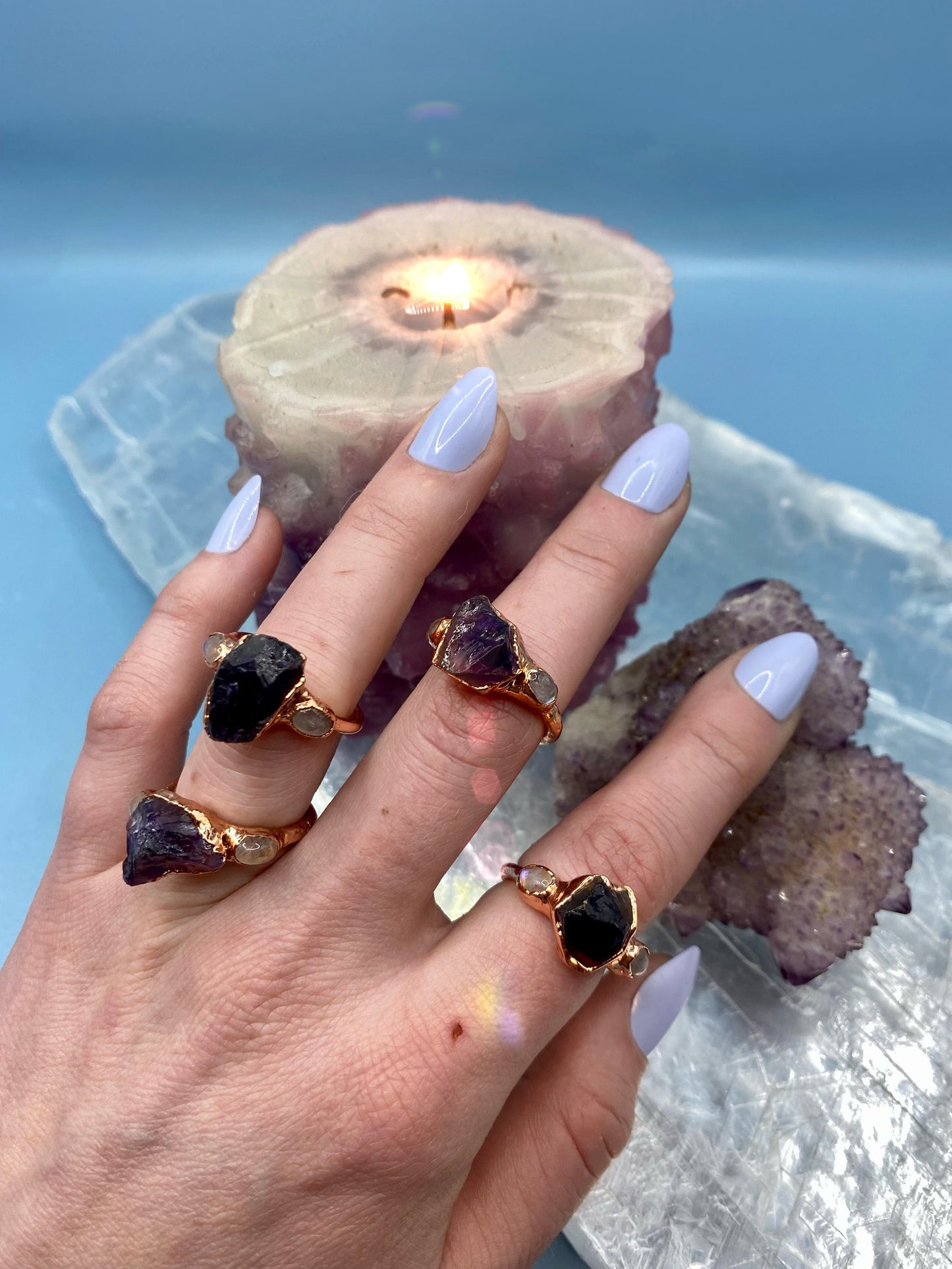 a hand wearing Amethyst Crystal Rings with moonstones